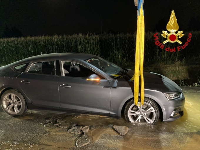 Cede un tubo dell’acqua: auto bloccata nella voragine